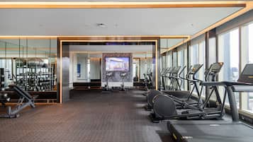 Un gimnasio moderno con cintas de correr, bicicletas estáticas y máquinas de pesas.