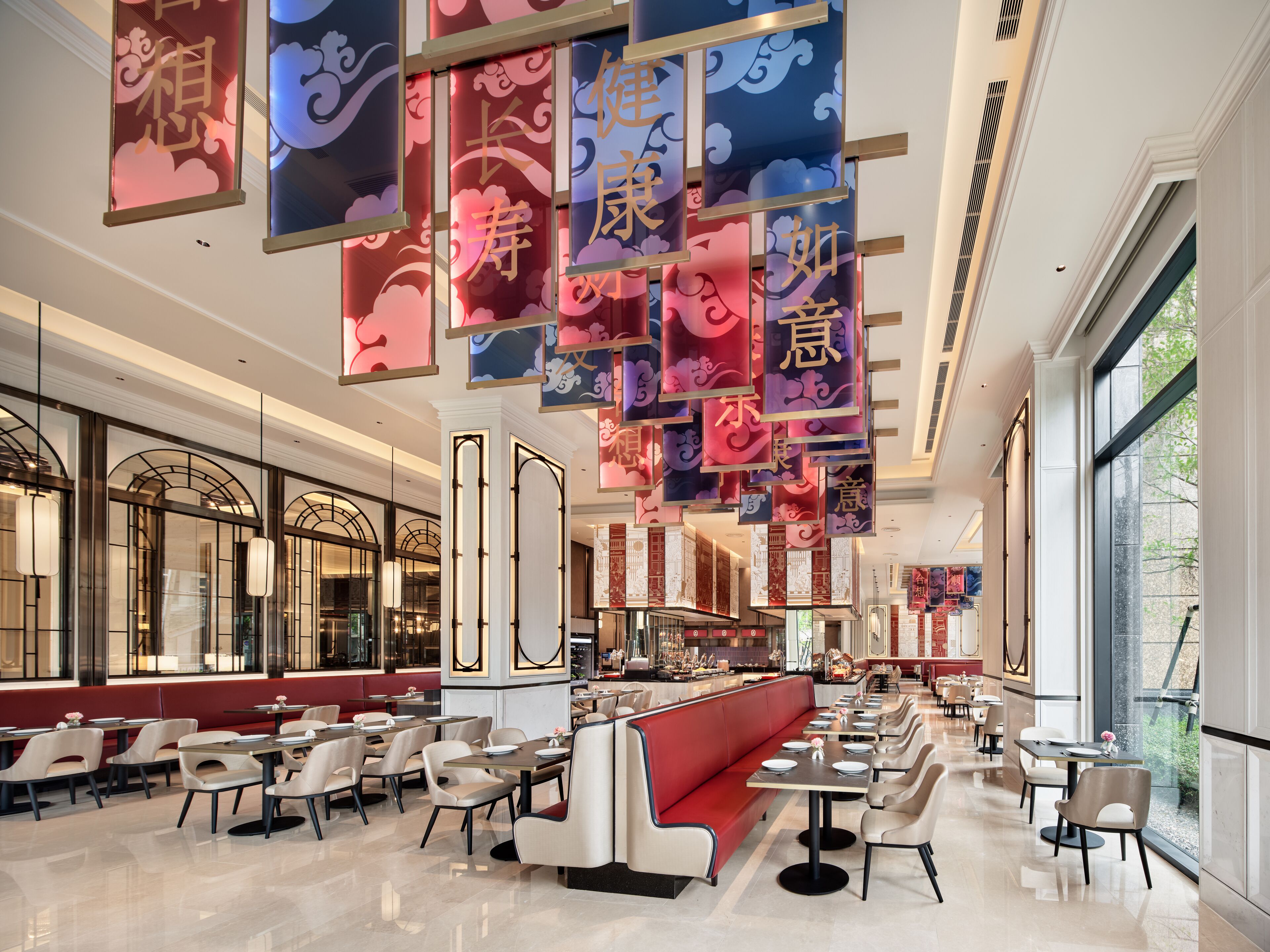 A spacious restaurant with high ceilings, modern seating, and decorative banners.