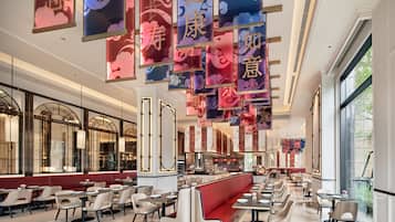A spacious restaurant with high ceilings, modern seating, and decorative banners.