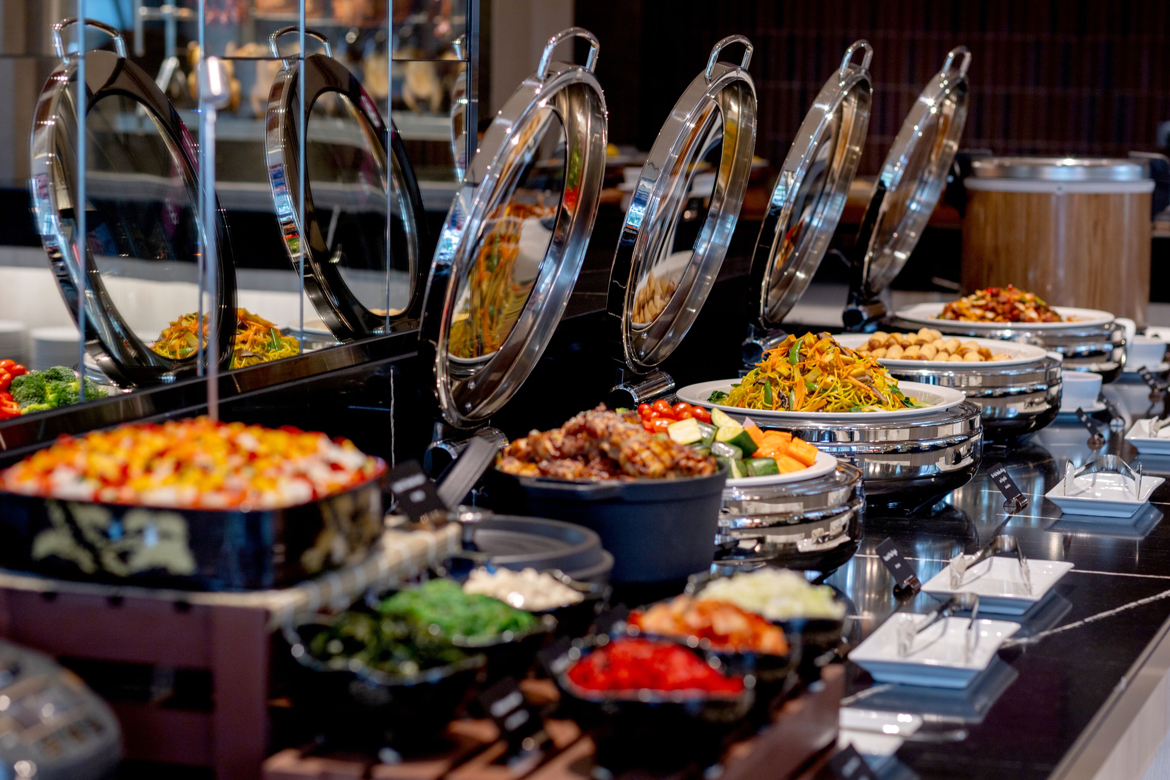 A buffet with various dishes and food containers.