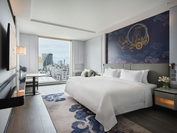 A modern hotel room with a large bed, a city view, a decorative wall mural, and a small table with a vase. - Grande Centre Point Surawong Bangkok (Bangkok)