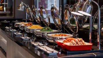 A buffet with various food items and utensils.