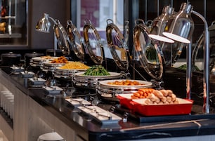 A buffet with various food items and utensils.
