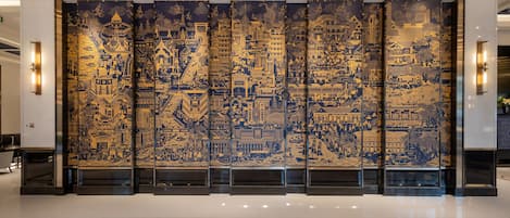 Un mural grande y detallado de un paisaje urbano en una pared de un moderno vestíbulo.