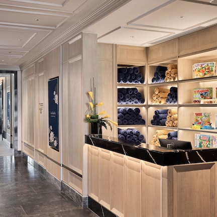 A hotel lobby with a reception desk, a fitness area, and a view of the city.