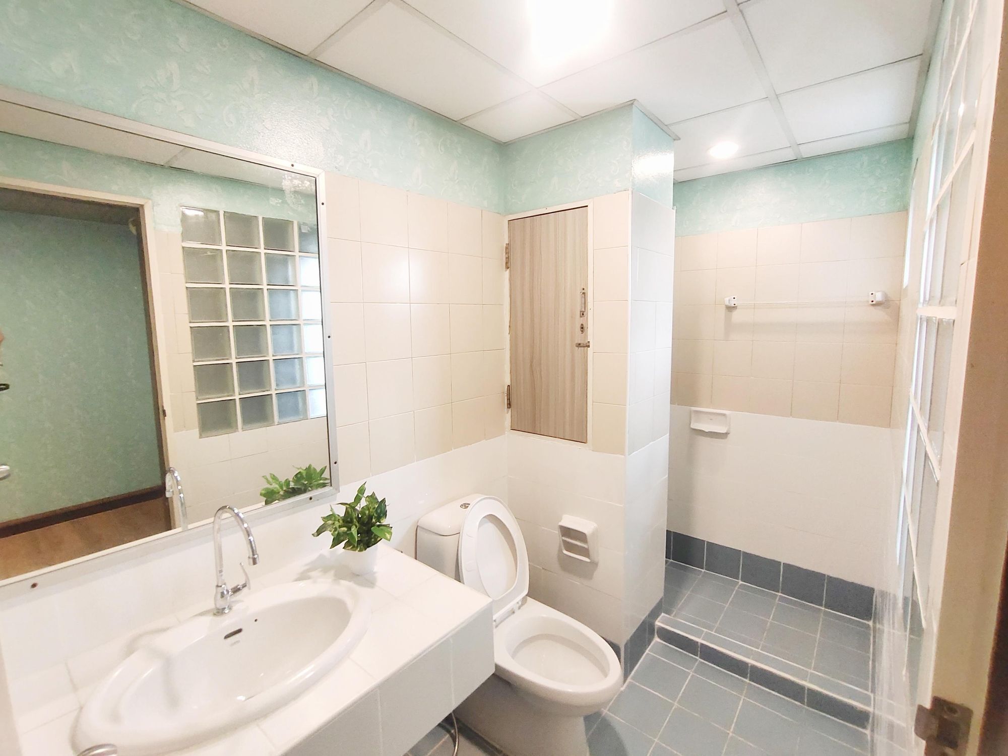 A bathroom with a sink, toilet, and shower area.