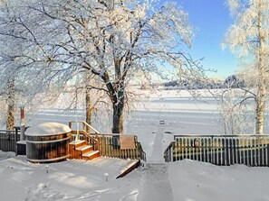 A snow-covered outdoor area with a wooden staircase leading to a cabin-like structure.