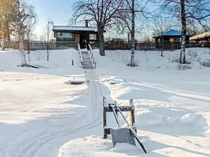 A snow-covered path leading to a building with a staircase.