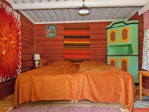 Una habitación con cama, lámpara, un cuadro y un armario verde.
