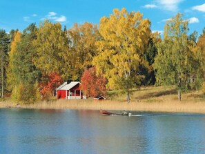 A lakeside cabin with a dock and a small boat.