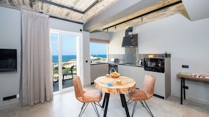 A modern kitchen with a view, a dining area with a round wooden table, and a balcony with a view.