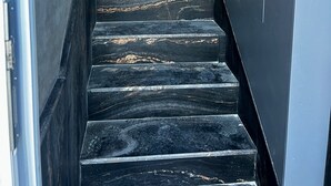 A staircase with dark, marble-like steps leading upwards. - Salini Suites Luxury Accommodation With Terrace and Sea View 101 (Iż-Żebbuġ)