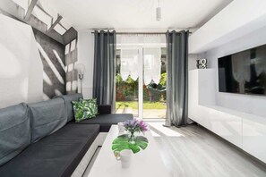 A modern living room with a sofa, coffee table, and a TV.