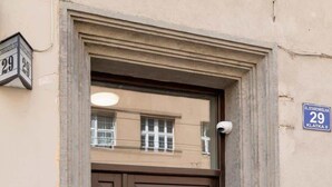A brown double door with a small step leading up to it, a mailbox, and a plaque on the wall. - Elegant Apartment | Air Conditioning, Balcony, Close to Market Square (Kraków)