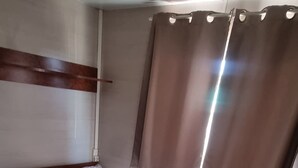 A bedroom with a bed, wooden flooring, a headboard, and a window with curtains. - Bungalow con Encanto a 600 Metros de la Playa las 3 Piedras. Aceptamos Mascotas (Chipiona)