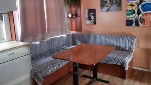 A room with a wooden floor, a large L-shaped sofa with patterned cushions, a wooden table, and a ceiling with recessed lighting. - Bungalow con Encanto a 600 Metros de la Playa las 3 Piedras. Aceptamos Mascotas (Chipiona)