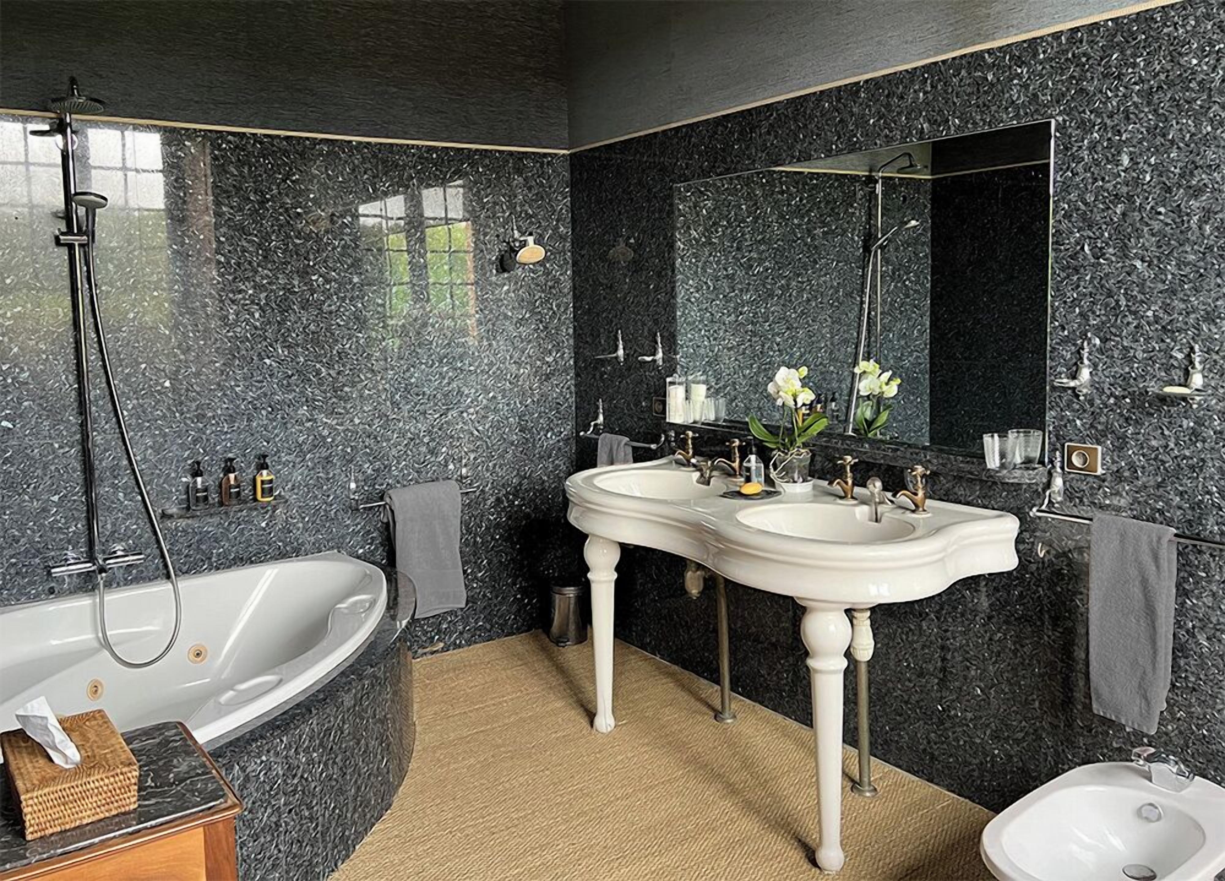 Ein modernes Badezimmer mit einer freistehenden Badewanne, zwei Waschbecken und einem Bidet.