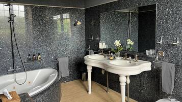 Ein modernes Badezimmer mit einer freistehenden Badewanne, zwei Waschbecken und einem Bidet.