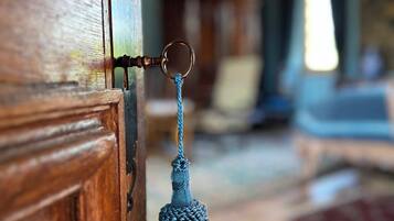 Una puerta de madera con cerradura metálica y un fleco azul colgando.