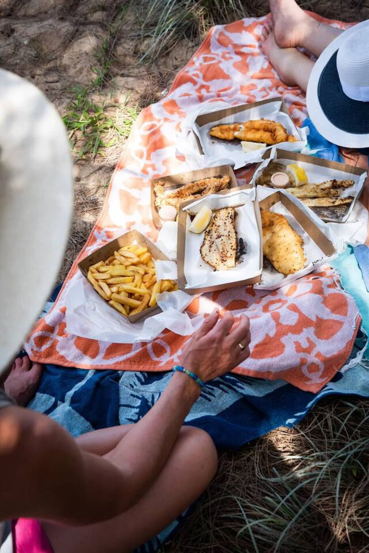 A picnic setup with food items on a blanket.