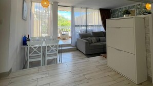 A modern apartment with a dining area, a sofa, and a kitchen.