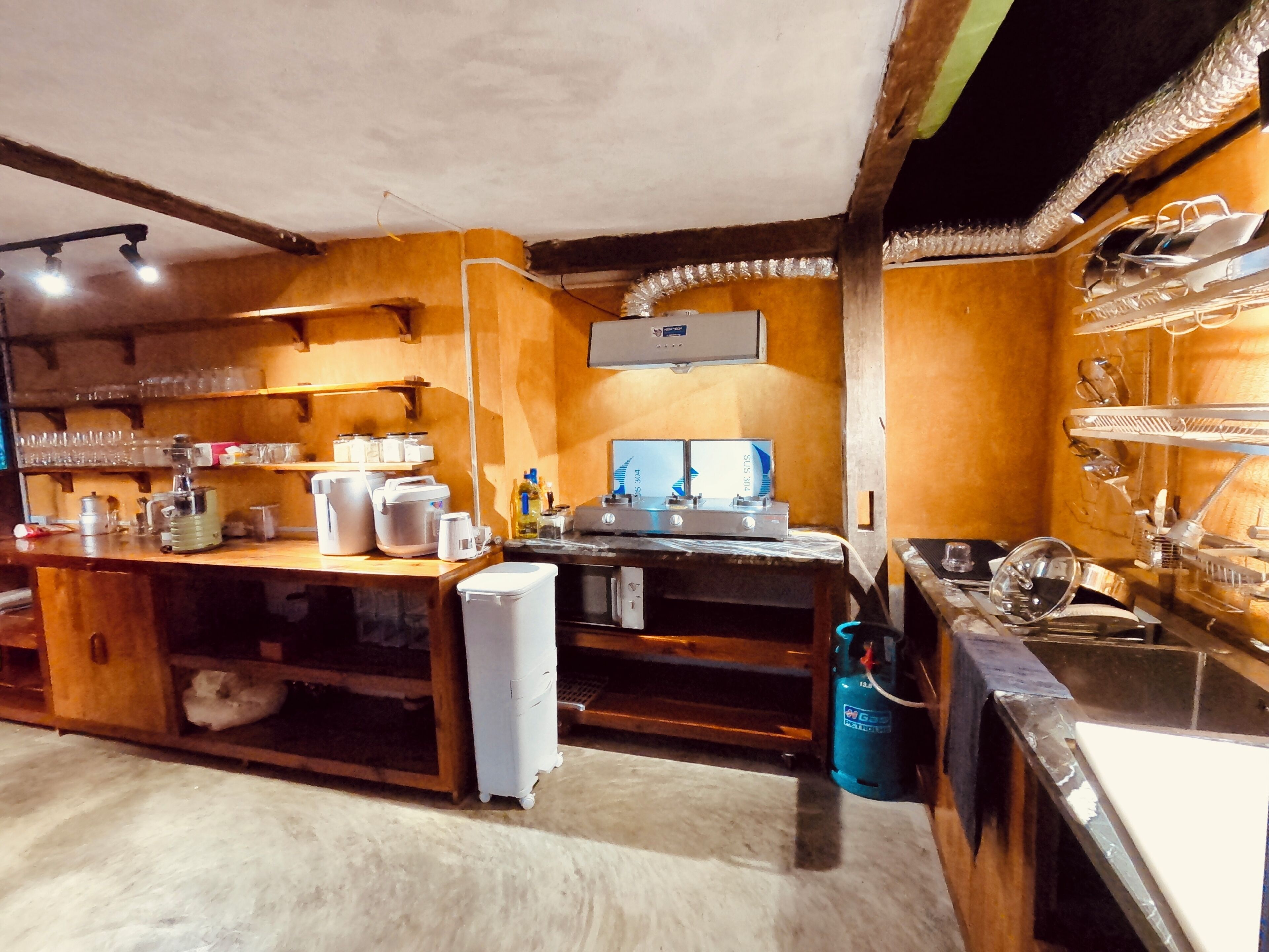 A kitchen with wooden cabinets, a refrigerator, a sink, and various kitchen appliances.