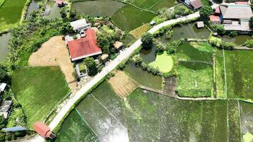 Eine Vogelperspektive auf eine ländliche Landschaft mit Feldern, Wasserflächen und vereinzelten Gebäuden.