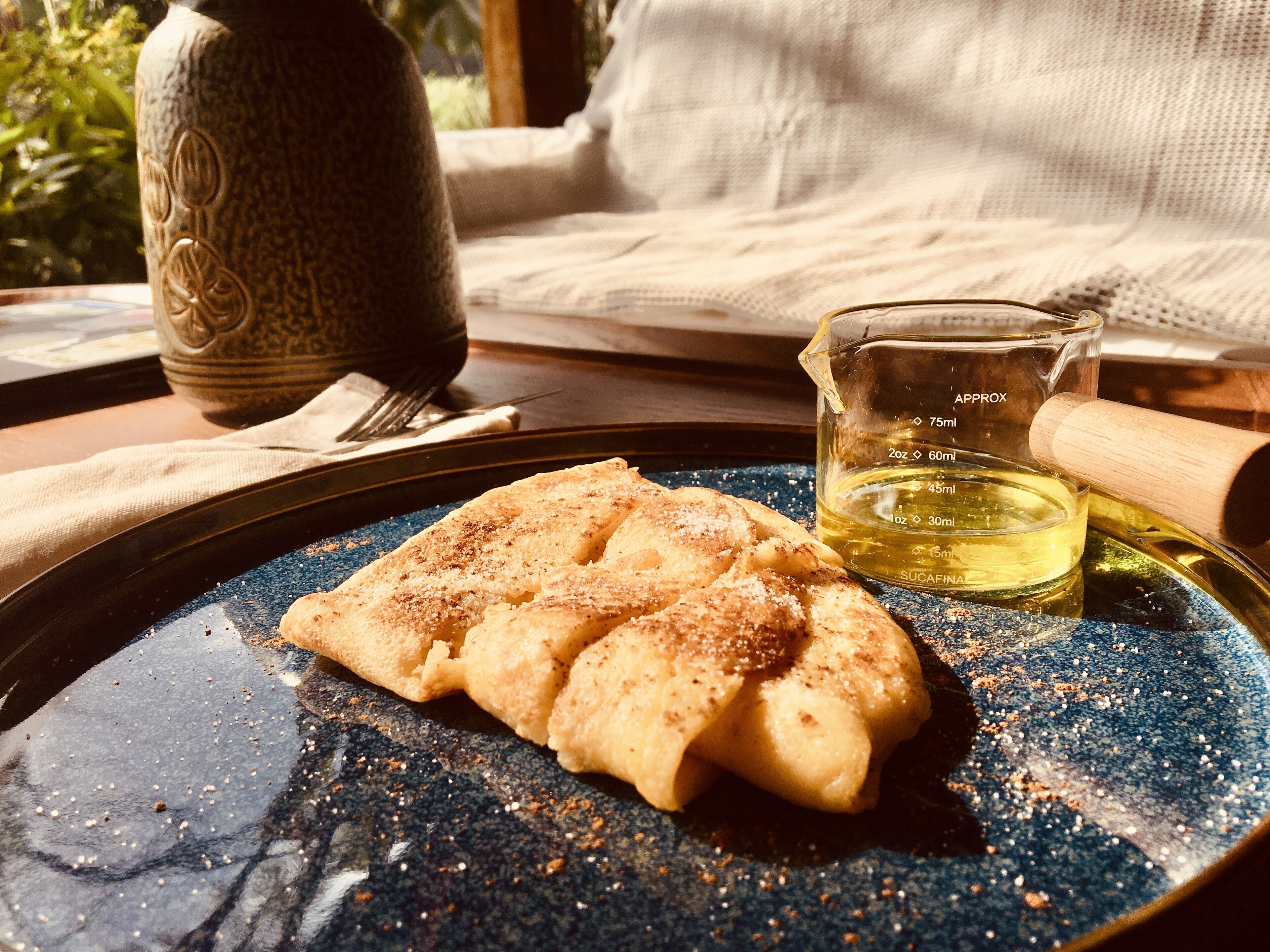 Lautasella on jälkiruokaa, mittakupissa nestettä ja pöydällä koristeellinen maljakko.