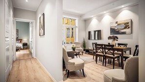 Ein modernes Wohnzimmer mit Essbereich, Holzboden und einem großen Fenster mit gelben Fensterläden.