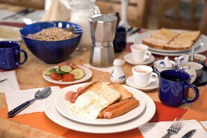 A breakfast table with various food items, a coffee cup, and a blue mug. - Nature Door Resort. Khuvsgul province. (Alag-Erdene)
