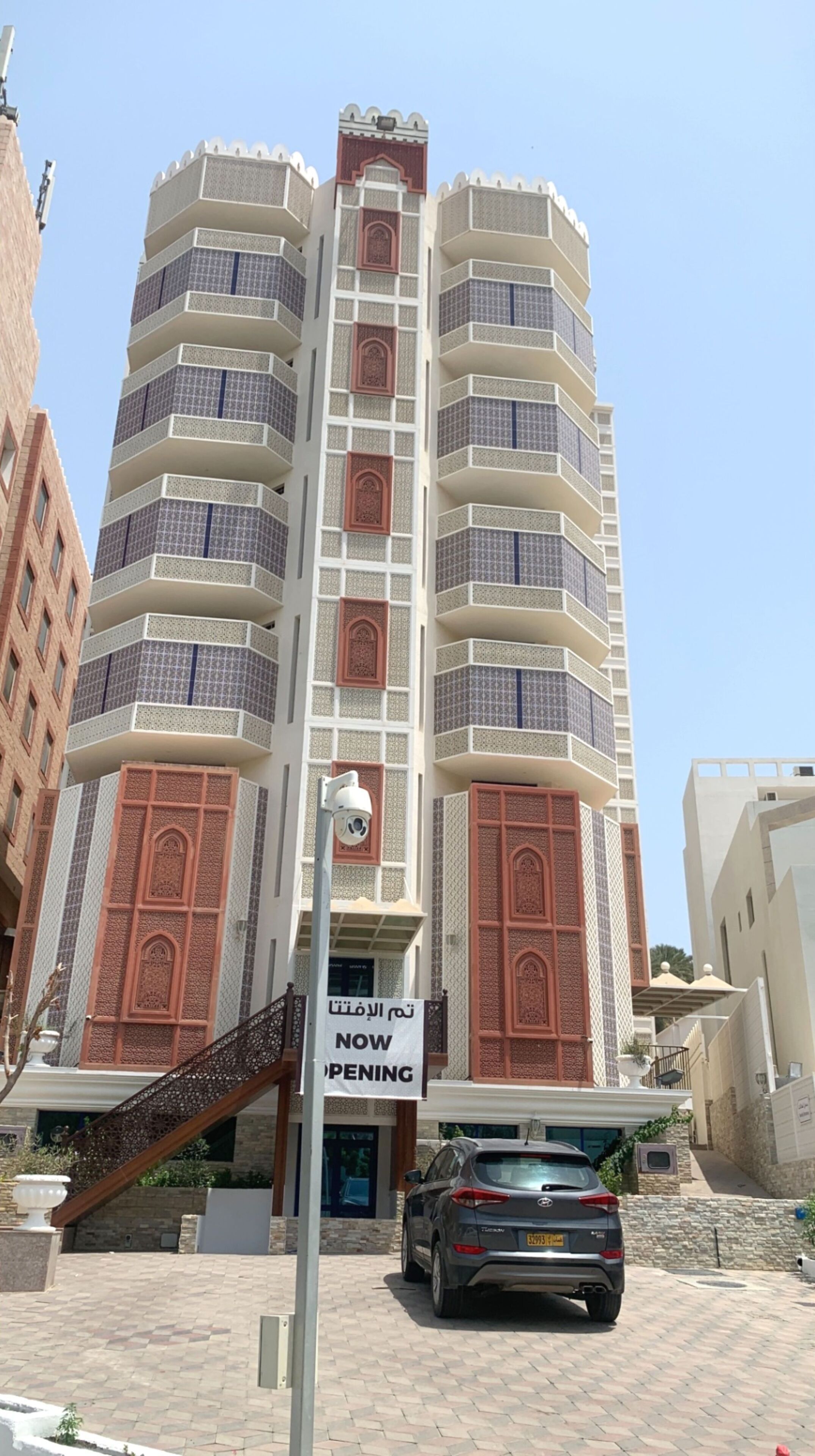 Um edifício de vários andares com uma placa indicando "ABERTURA IMINENTE".