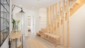 Ein modernes Interieur mit einer Holztreppe, einer Bank und einem Tisch mit einem Glasbehälter.
