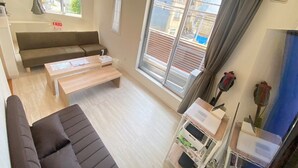 Een moderne woonkamer met een bank, een salontafel en een klein karretje met dozen.