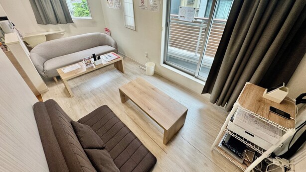 Een moderne woonkamer met een bank, een salontafel en een tv-meubel met elektronische apparaten.