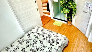 Een kleine slaapkamer met een bed, een trap en een groene plant.
