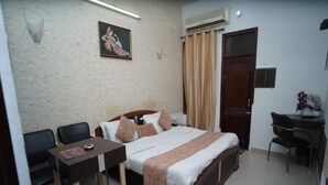 A hotel room with a bed, a desk, a chair, a TV, and a window with curtains. - HOTEL MOON (Hisar)