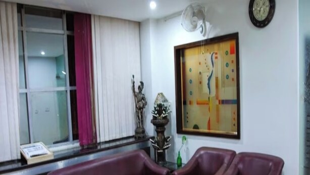 A living room with a purple sofa set, a glass coffee table, and a painting on the wall. - HOTEL MOON (Hisar)