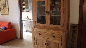 A wooden cabinet with glass doors, a red sofa, and a 'WELCOME' sign. - Holiday apartment with air conditioning, swimming pool, tennis (Colà di Lazise)