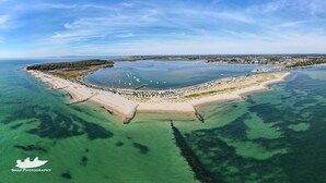 An aerial view of a coastal area with a clear water body, a sandy beach, and a row of hexagonal structures along the shore. - Shoreline - a spacious, well appointed lodge overlooking Christchurch Harbour. (Christchurch)
