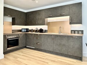 Enjoy cooking in this well-equipped kitchen with oven, microwave, kettle, and toaster.