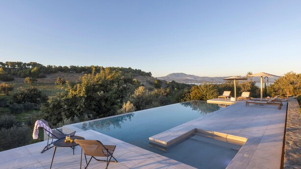 A modern outdoor pool area with lounge chairs and a pergola, surrounded by natural landscape and hills. - Euphonia Residence by Athina Hospitality (Ermionida)