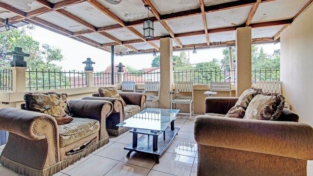 A covered outdoor seating area with cushioned sofas and a glass coffee table. - OYO 92851 Homestay Borobudur Specpacker Syariah (Borobudur)