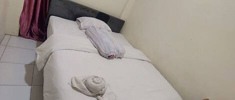 Una habitación pequeña y sencilla con una cama, una silla de madera y una mesa.