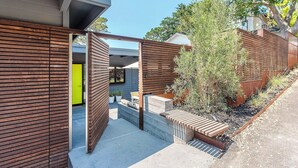 Een modern gebouw met een houten gevel en een felgroene deur.