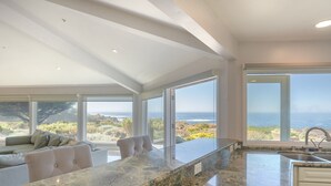 A modern kitchen with a large island, a built-in oven, and a view of the ocean. - 3906 Ocean's One Eleven ~ Unobstructed Ocean View! (Carmel)