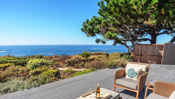 A deck with wicker furniture, a bottle of wine, and magazines. - 3906 Ocean's One Eleven ~ Unobstructed Ocean View! (Carmel)
