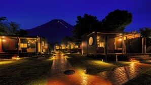 A row of cabins with a mountain in the background, connected by a paved walkway. - piilo asobi&stay (Yamanakako)