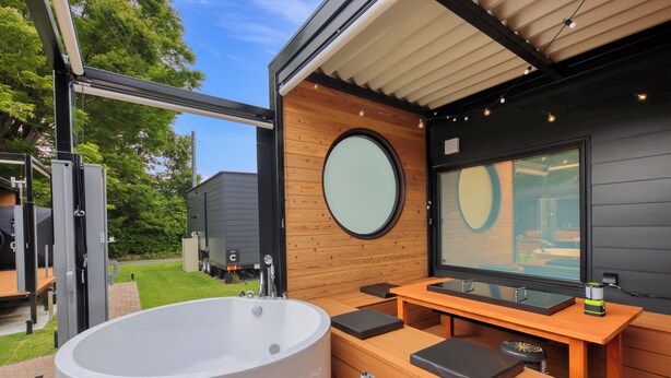 A modern bathroom with a large bathtub, wooden vanity, and a large mirror. - piilo asobi&stay (Yamanakako)