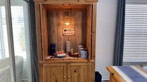 A wooden cabinet with a coffee bar sign, a basket of coffee packets, and a coffee maker. - Recently Updated & Complete w/Golf Cart, Coffee Bar, & MORE! (The Villages)