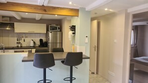 A modern kitchen with a central island, bar stools, and a dining area. - Riesling, Gites des Dix Vins (Dangolsheim)